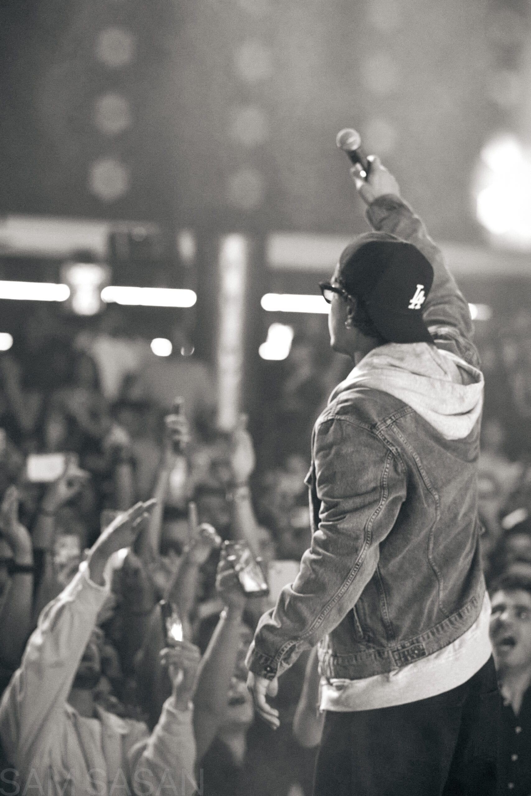 Black and white shot of artist reaching out to the concert crowd