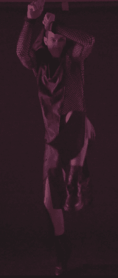 Model performing dynamic movement in red lighting