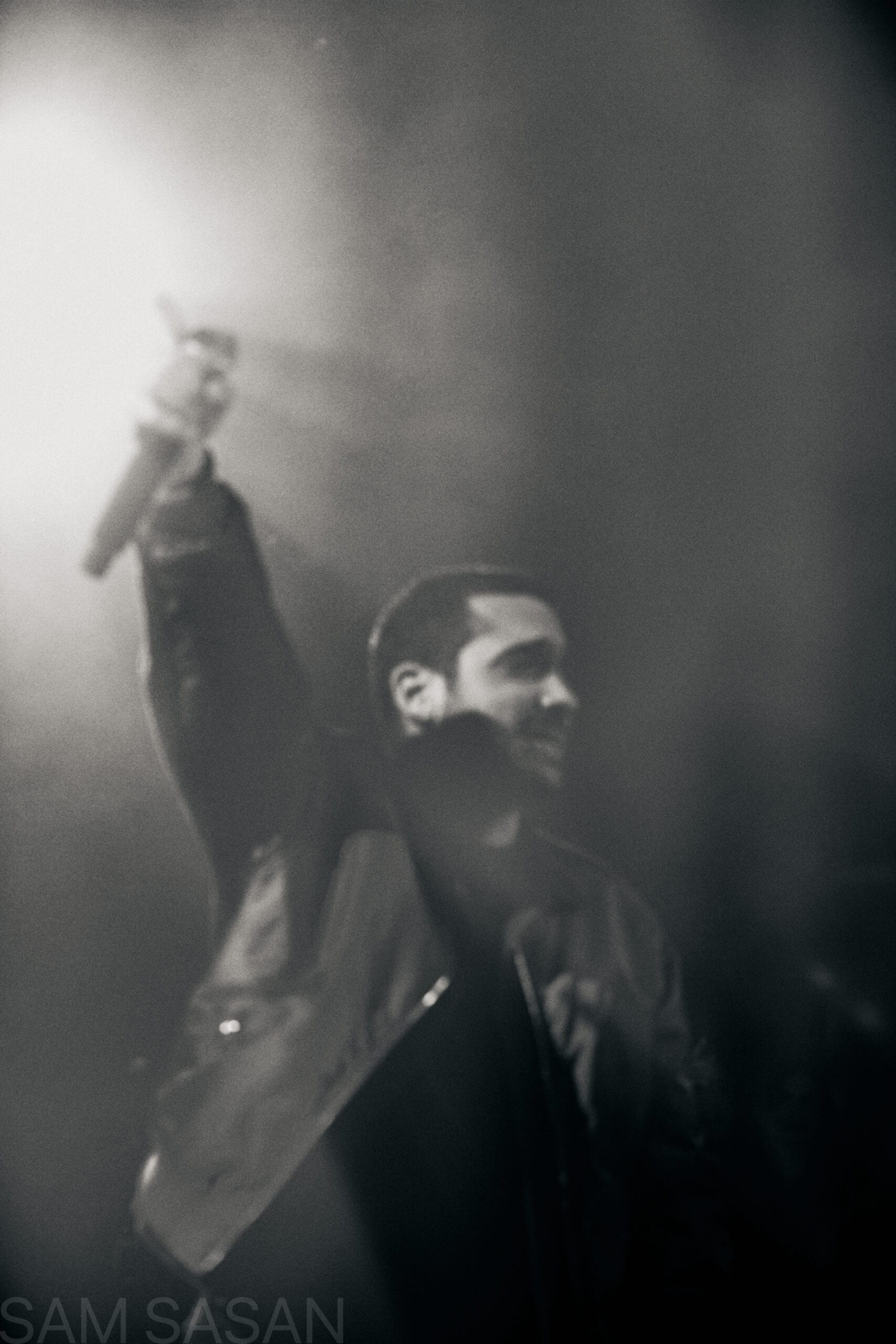 Artist raising the microphone in a dramatic black and white portrait