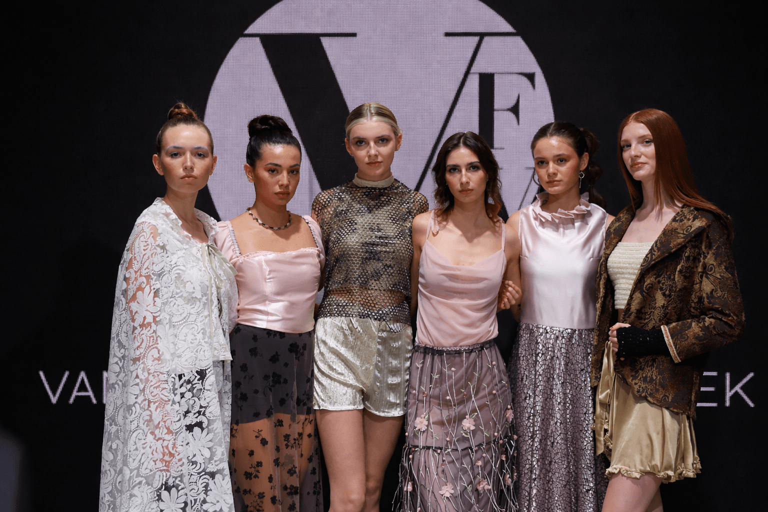 Diverse lineup of fashion models posing together on the D4 runway at Vancouver Fashion Week