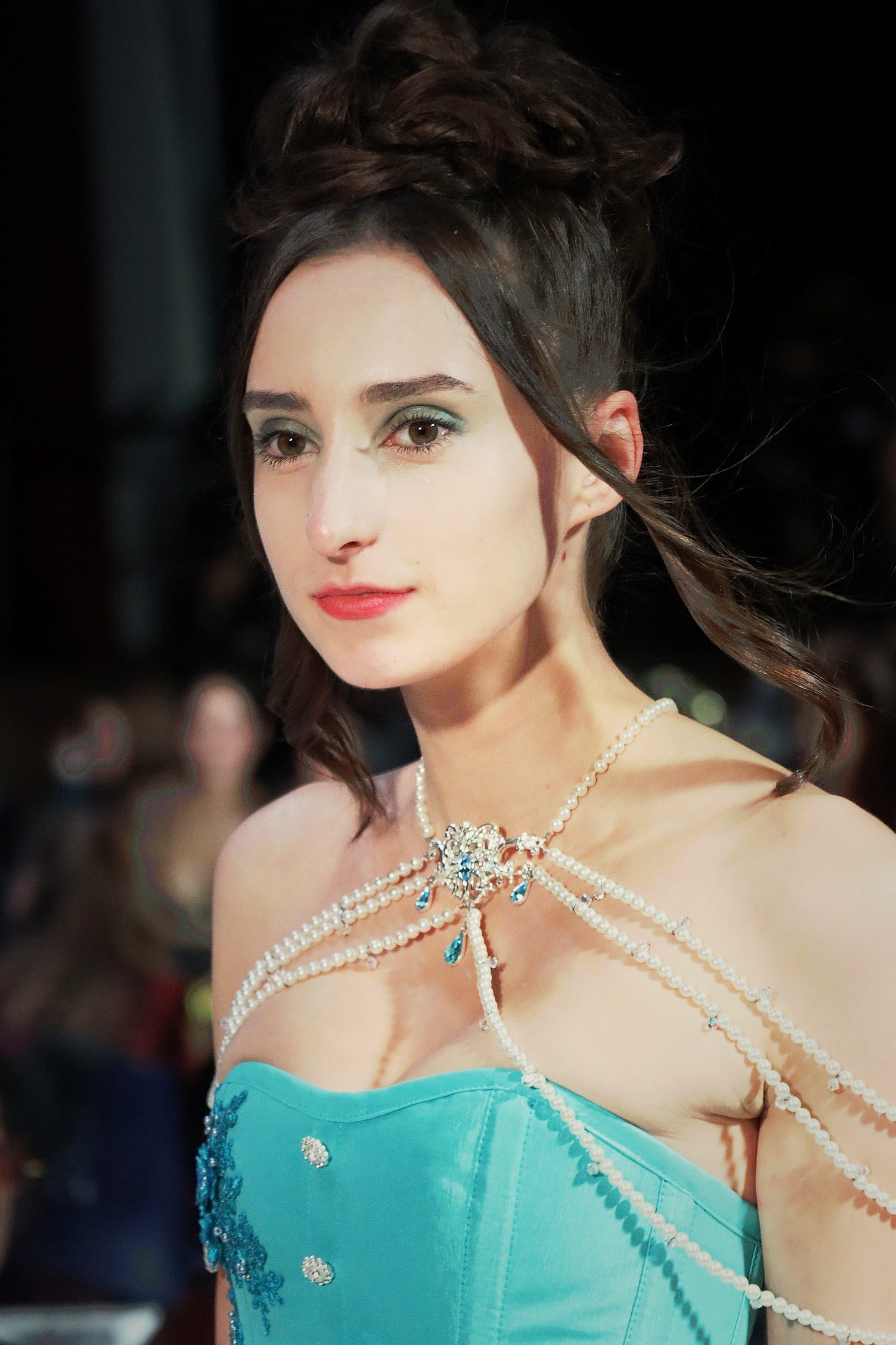 Back view of a model wearing a white backless draped dress on the runway